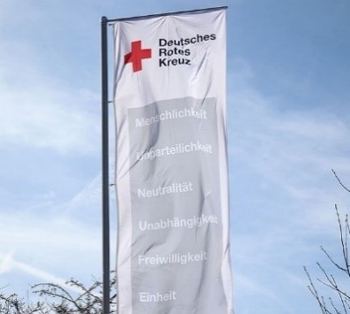 Pflegekraft betreut liebevoll einen älteren Menschen in heller Pflegeeinrichtung